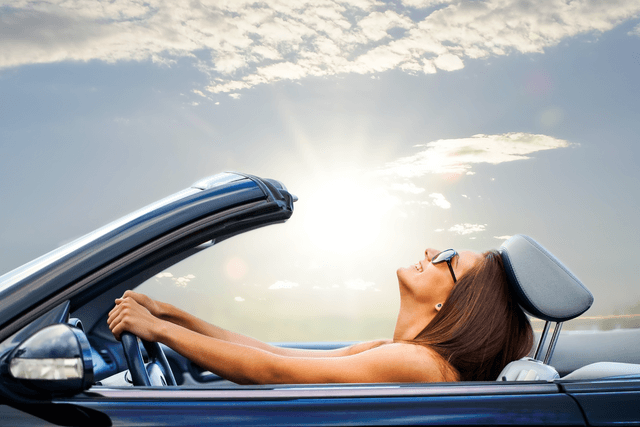 Woman driving in open roof car and sun shining - driving lessons Redditch.